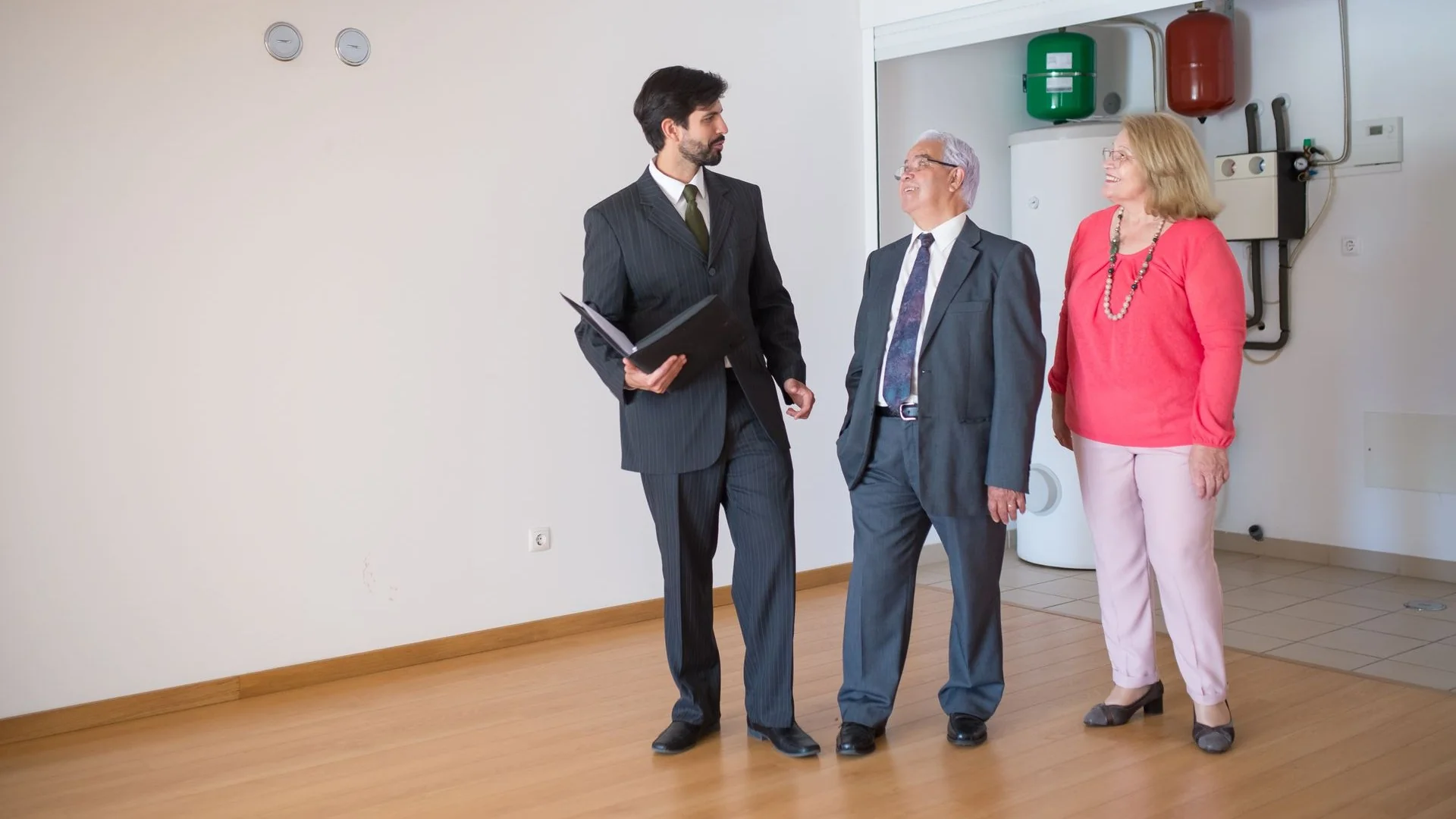 An older couple walks through a home with a professional while discussing their housing options